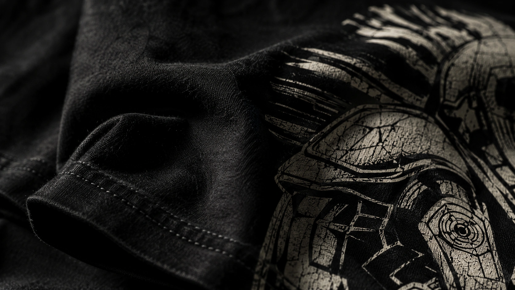 Close-up of black T-shirt fabric and cracked screen-print detail